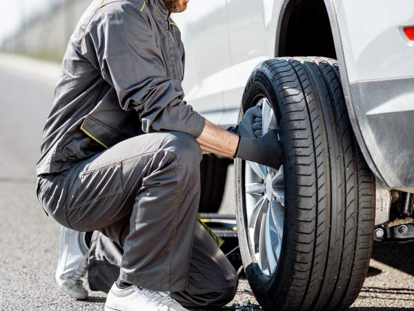 Chacon Towing Tow Truck Operator Changing Tire Roadside in San Antonio