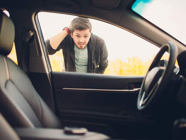 Man looking through car window at keys locked inside car San Antonio